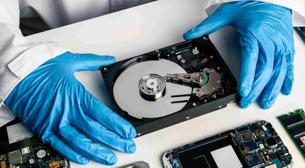 Technician recovering data from a failed hard drive in a lab, by CARE in Singapore