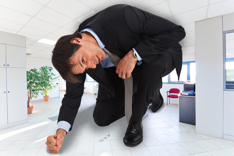 Businessman cramped in a small office, a metaphor for a Singapore business that has outgrown its IT support, helped by CARE